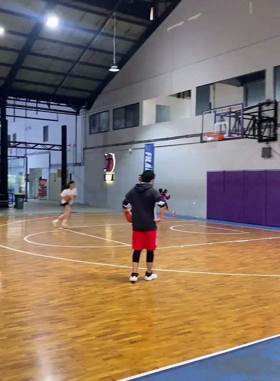 The wooden-floor basketball court with purple wall pads